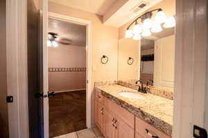 Bathroom featuring tile patterned floors, vanity, a textured ceiling, and ceiling fan