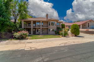 Mediterranean / spanish-style home with a balcony, a tile roof, a chimney, and stucco siding