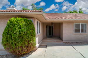 Property entrance featuring stucco siding and a tiled roof