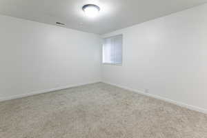 Empty room featuring carpet floors and baseboards