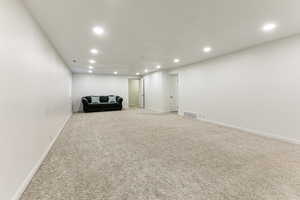 Unfurnished room with recessed lighting, light colored carpet, and baseboards