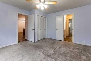 Unfurnished bedroom featuring carpet flooring, baseboards, a chandelier, and a closet