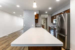 Kitchen featuring stainless steel appliances, a sink, light countertops, light wood-type flooring, and recessed lighting