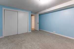 Unfurnished bedroom featuring carpet, baseboards, and a closet