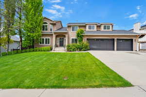 View of front of property with stucco siding, concrete driveway, and a front lawn