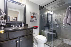 Full bath with toilet, vanity, tile patterned floors, a shower stall, and a textured ceiling