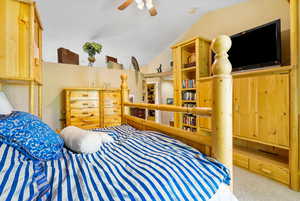 Bedroom featuring carpet, vaulted ceiling, and ceiling fan
