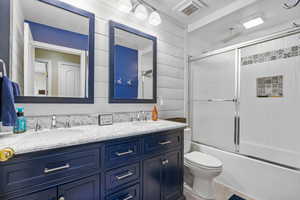 Bathroom featuring double vanity, toilet, a combined bath / shower with rainfall shower, and tile patterned floors