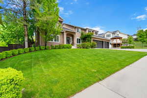 View of front facade featuring driveway, stucco siding, and a garage