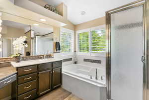 Full bathroom featuring a stall shower, vanity, a bath, and lofted ceiling