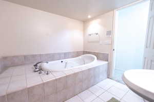 Bathroom featuring tile patterned floors and a bath
