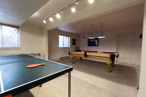 Playroom featuring baseboard heating, rail lighting, carpet flooring, and billiards
