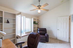 Home office featuring carpet flooring, vaulted ceiling, ceiling fan, and baseboards