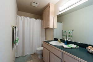 Bathroom with vanity, toilet, and tile patterned floors