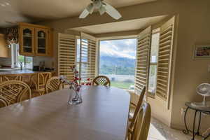 Dining room with a ceiling fan, light tile patterned floors, and baseboards