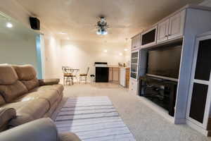 Living room with light colored carpet and a ceiling fan