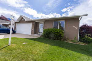 Ranch-style house featuring brick siding, a garage, concrete driveway, and a front yard