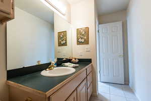 Bathroom with tile patterned flooring, baseboards, and vanity