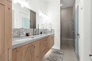 Bathroom featuring decorative backsplash, double vanity, a shower stall, light tile patterned flooring, and recessed lighting