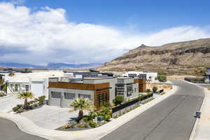View of front of home with a mountain view, concrete driveway, stucco siding, and a garage