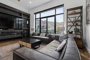 Living area with dark wood-type flooring, a mountain view, plenty of natural light, and recessed lighting