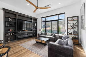Living room with recessed lighting, a ceiling fan, and light wood-style flooring