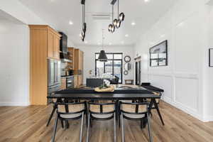 Dining space with light wood-type flooring, recessed lighting, and a decorative wall