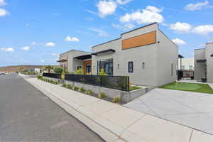 View of front of house featuring a putting area and stucco siding