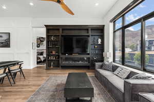 Living area with ceiling fan, light wood finished floors, and recessed lighting