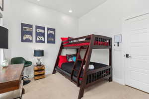 Bedroom featuring light carpet, recessed lighting, and an office area