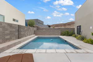 View of swimming pool with a patio, a fenced backyard, and a mountain view
