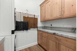 Kitchen featuring light wood-style flooring, light stone countertops, and light brown cabinetry