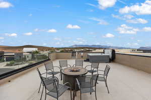 View of patio featuring a fire pit, a mountain view, and a hot tub