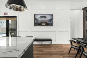 Dining area with a decorative wall and dark wood-style floors