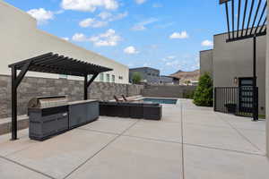 Fenced backyard with a pergola, a patio, a mountain view, and exterior kitchen