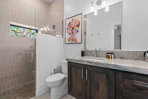 Bathroom with vanity, walk in shower, and light tile patterned flooring