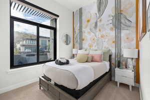 Bedroom with light colored carpet and baseboards