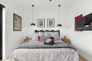Carpeted bedroom featuring baseboards and ceiling fan