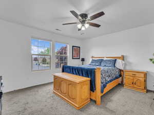Bedroom with ceiling fan, light carpet, baseboards, and visible vents