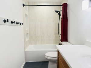 Full bathroom with toilet, vanity, tile patterned floors, and shower / washtub combination