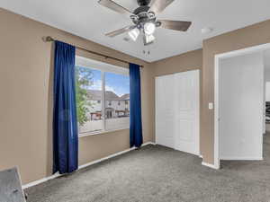 Unfurnished bedroom featuring carpet, a closet, visible vents, baseboards, and ceiling fan