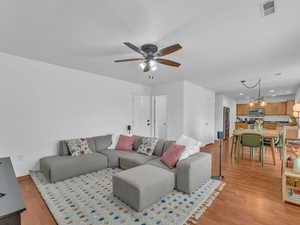 Living room featuring visible vents, recessed lighting, light wood finished floors, ceiling fan, and baseboards