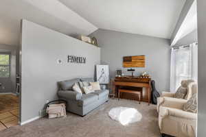 Living room with light colored carpet, bay window, and high vaulted ceiling