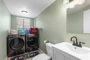 Clothes washing area featuring independent washer and dryer, baseboards, and light tile patterned flooring