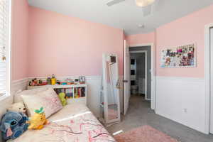 Carpeted bedroom with a ceiling fan