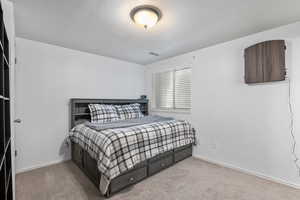 Bedroom featuring a textured ceiling, carpet, and baseboards