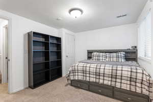 Bedroom with carpet floors and a textured ceiling