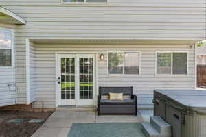 Doorway to property featuring a hot tub and a patio