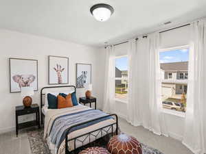 Bedroom featuring light carpet, multiple windows, and baseboards