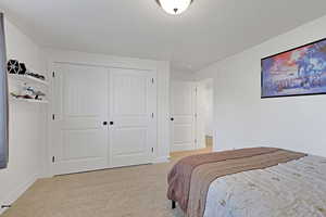 Carpeted bedroom featuring a closet